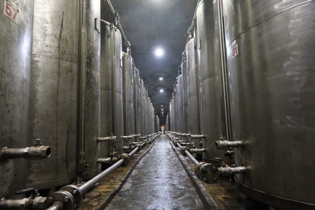 Industrial stainless steel tanks in a long hallway.