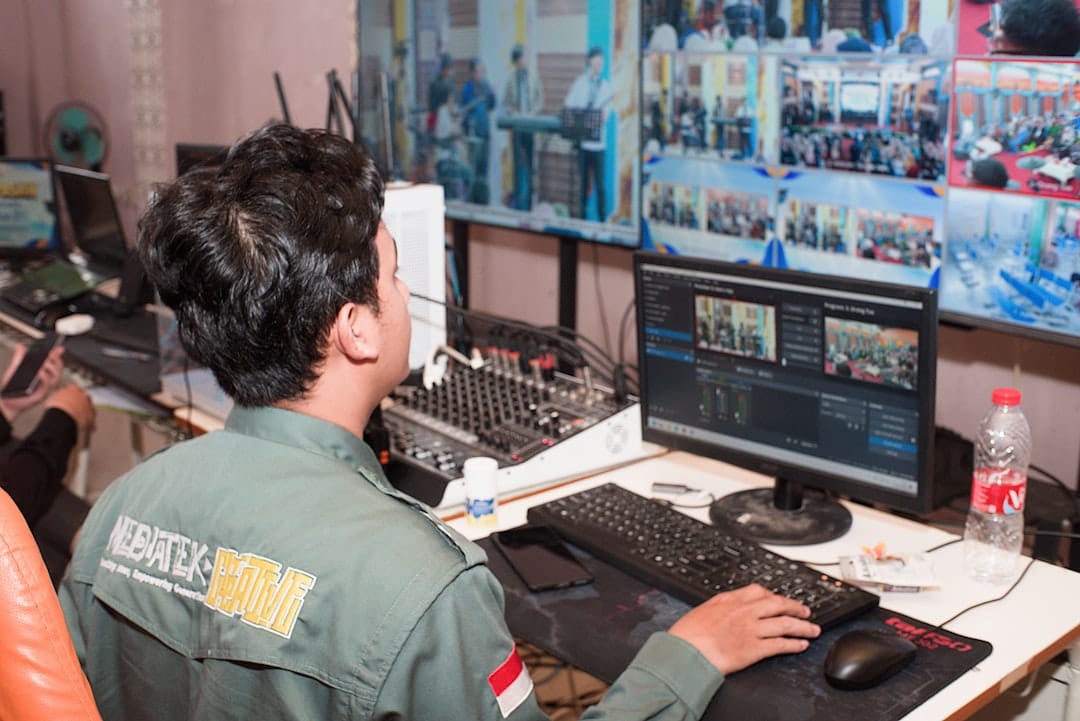 Man in uniform operating video and audio equipment.