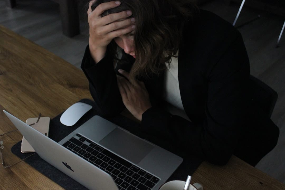 stressed woman with head in hands at laptop